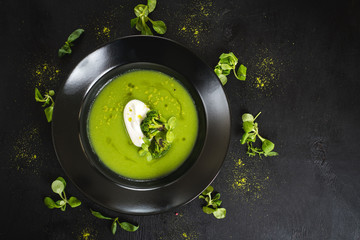 Green cream soup from broccoli on black background