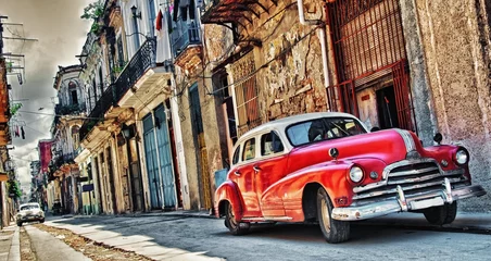 Papier Peint photo Havana Vieille voiture américaine garée avec le bâtiment de la Havane en arrière-plan