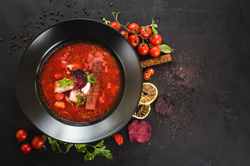 Red soup ukrainian borsch on black background. Top view
