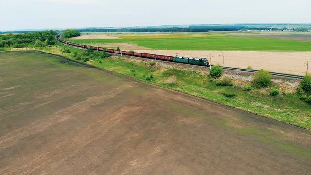 A long freight train goes on a railway. Aerial view.