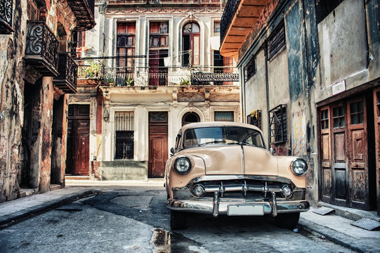 Old classic car in a street of havana with buildings in background