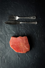 Fototapeta na wymiar Raw Tuna Steak on Dark Stone Background