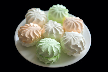delicious colorful merengues on  black background