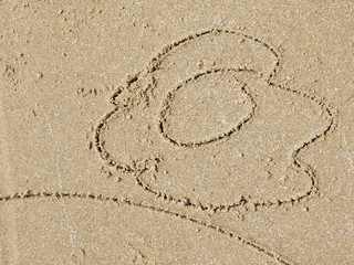 Flower drawn in the sand/Sea background with a sand/simple flower drawing in the sand on the beach