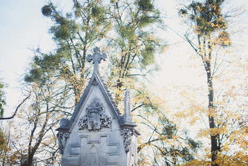 Pale depressive statues, monuments, and gravestones of the cemetery on sunny autumn aftetnoon....