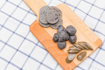 black chicken ball and sausage on wood dish