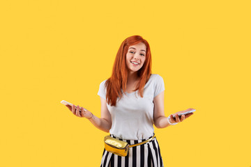 Positive mood. Happy delighted woman smiling to you while holding smartphones in her hand