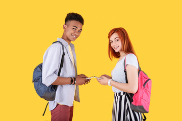 Young people. Positive young couple looking at you while holding their gadgets