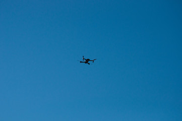 Black quadrupter with propellers flies in the sky and photographs landscapes