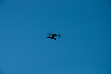 Black quadrupter with propellers flies in the sky and photographs landscapes