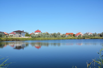 Fototapeta na wymiar Cottage houses on the lake bank with beautiful view.