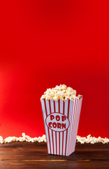 Red and White Bucket Of Popcorn on red background
