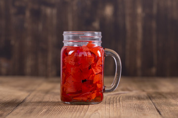 Red poppy flower tea drink in glass mug on wooden background. Concept of healthy eating