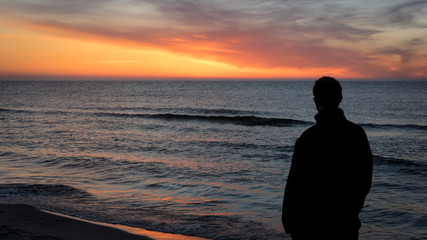 Fototapeta premium Man Watching Sunset from Beach Baltic Sea Poland 