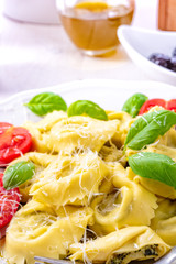 ravioli with spinach filling, grated cheese and cocktail tomatoes