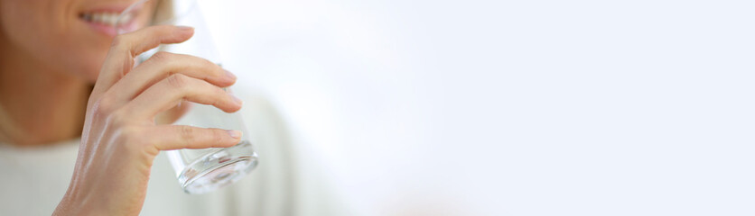 Closeup on glass of water held by woman's hand, template