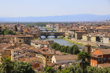 Fototapeta na wymiar View of the roofs of houses of Florence, the Arno River and bridges, Italy