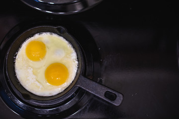 From the top view of frying eggs in a black skillet