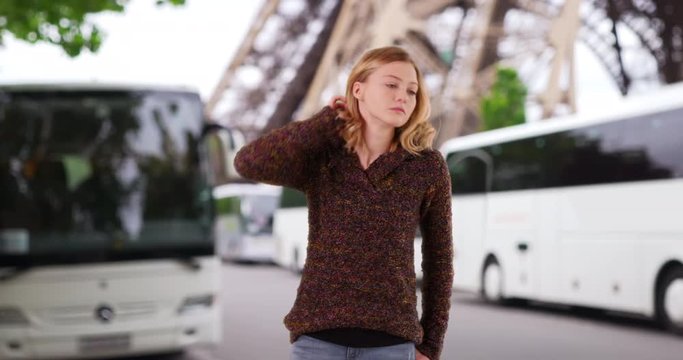 Pretty Caucasian girl in her 20s in Paris street, Portrait of attractive young woman by the Eiffel Tower looking around, 4k