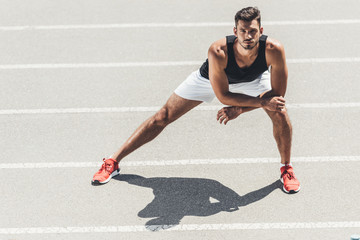 male athlete exercising on running track at sport playground