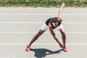 young sportsman exercising on running track at sport playground