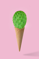 Ice cream cone with green cactus on pink background. Creative minimal concept.  Holiday concept.