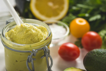 Homemade Green Avocado Spread in Jar. Vegan Raw and Healthy Fresh Food Concept.