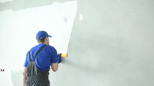 refurbishment. Worker spackling a wall with putty
