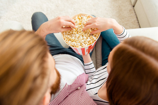 Take hold basket box friendship leisure lifestyle partners cuddle day freetime concept. Top overhead close up view photo of two people in love spending time together eating tasty pop-corn watch comedy