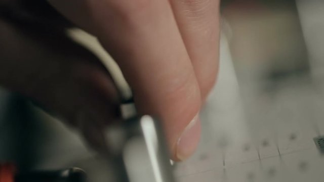 Extremely close up shot of musician's hand tune synthesizer