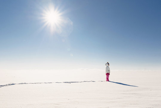 Girl walking in a snowy rural landscape