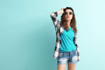Stylish young woman in casual clothes on color background