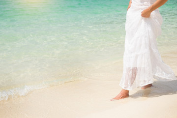 Fototapeta na wymiar a beautiful carefree Woman relaxing at the beach enjoying her sun dress freedom wear.