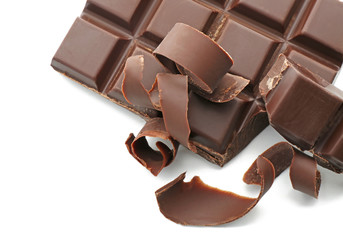 Pieces of chocolate and curls on white background