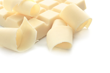 Piece of chocolate and curls on white background