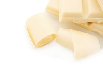 Pieces of chocolate and curls on white background