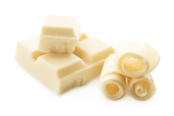 Pieces of chocolate and curls on white background