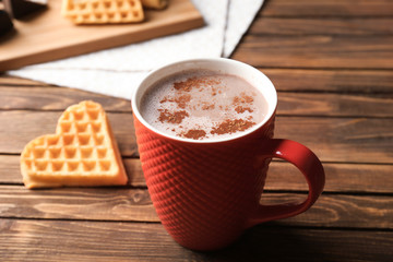 Cup of tasty cocoa drink on wooden table