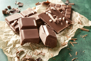 Tasty milk chocolate with almonds on parchment