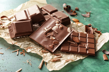 Tasty milk chocolate with almonds on parchment