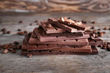 Tasty chocolate with coffee beans on wooden background