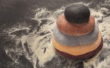 Fototapeta na wymiar Colorful fresh pasta dough on black table