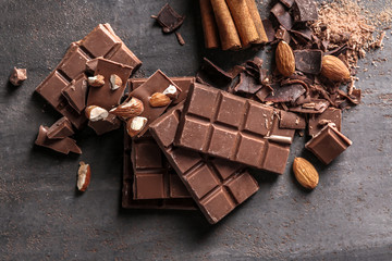 Milk chocolate pieces with almonds on grey background