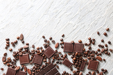 Chocolate pieces with coffee beans on light textured background