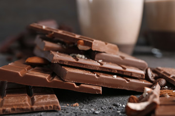 Milk chocolate pieces with almonds on dark background, closeup
