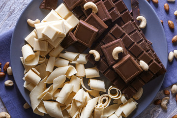 Plate with dark and white chocolate on table, top view