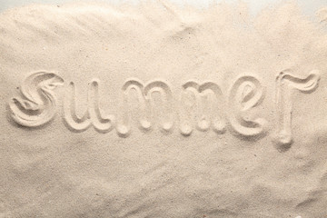 Word SUMMER written on beach sand