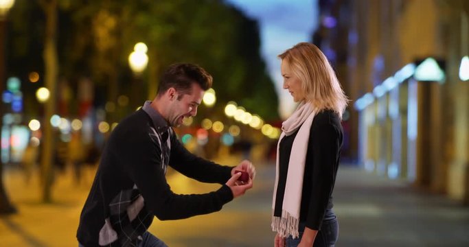 Man proposes to his beautiful girlfriend on the Champs-Elysees at night, Happy and romantic couple get engaged in Paris, 4k