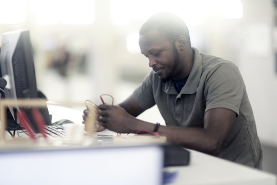 Man sitting at desk controlling a device with flow meters