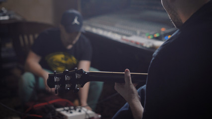 Two professional musicians sitting in a recording studio together.